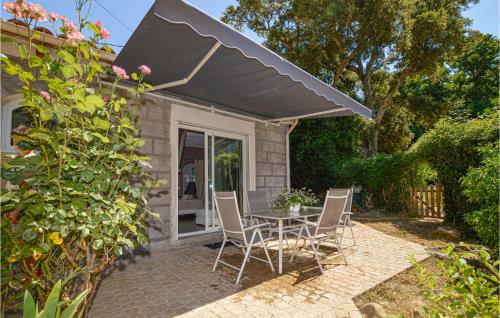 patio con tavolo e sedie sotto ombrellone di Awesome Home In Petreto Bicchisano a Petreto-Bicchisano