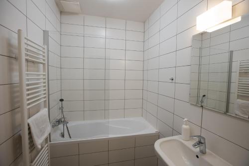 a white bathroom with a tub and a sink at Riverside SPIRIT in Prague
