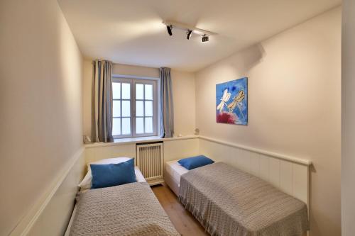 a bedroom with two beds and a window at Apartmenthaus Budersandstraße 53 in Hörnum