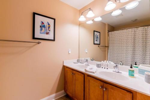 a bathroom with a sink and a large mirror at Old Town Bluffton Charm in Bluffton