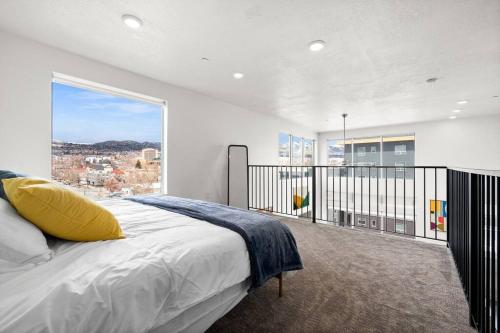 um quarto com uma cama e uma grande janela em LUX Penthouse Oasis-Heart of SLC em Salt Lake City
