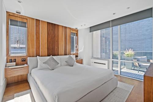 a bedroom with a white bed and a large window at The Gotham Hotel in New York