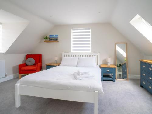 a bedroom with a white bed and a red chair at Pass the Keys Town Centre cottage with garden and parking in Cheltenham