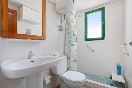 ein Badezimmer mit Waschbecken und Toilette und einem Fenster in der Unterkunft Dunes resort to relax Wifi in Corralejo