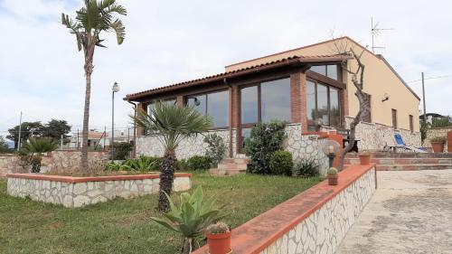 ein Haus mit einer Palme davor in der Unterkunft Villa Delia in Balestrate