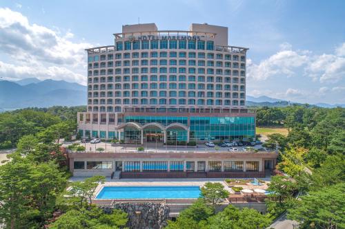 ソクチョにあるホテル マレモンスの大きな建物の正面にプールがあります。