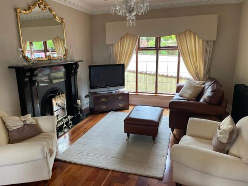 sala de estar con chimenea y TV en Taylors Hill Luxury Guest House, en Galway