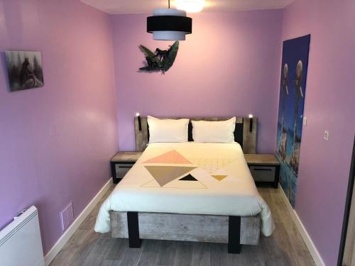een slaapkamer met een bed in een paarse muur bij Le Refuge d'Helix in Viviez