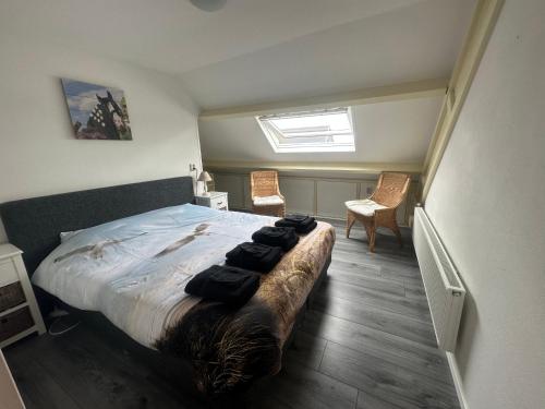 a bedroom with a bed with black clothes on it at Het Tinkerparadijs, paarden, rust en ruimte. in Burgh Haamstede