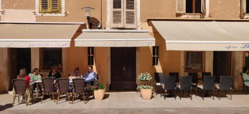 a group of people sitting at a table under umbrellas at Luxury Rooms Contessa Vitali in Zadar