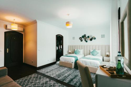 a bedroom with two beds and a couch and a table at Quinta da Costinha in Alijó
