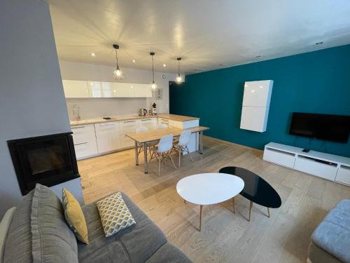 a living room with a couch and a table and a kitchen at Appartement au coeur d'Arbois in Arbois