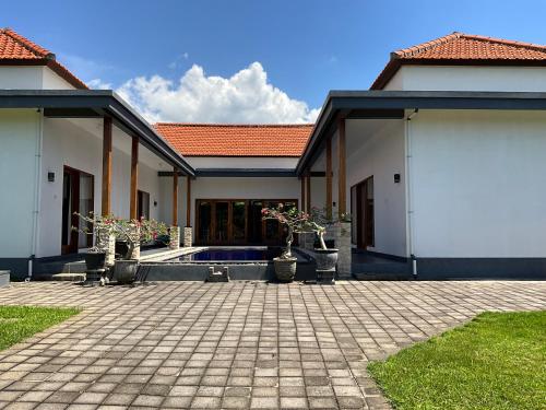 a house with a patio and a courtyard at Villa Rosa East Bali in Karangasem