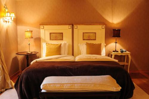 a large bed in a room with two lamps at Casas Do Coro in Marialva