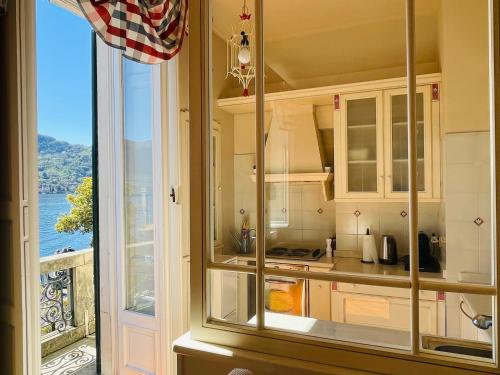 uma cozinha com vista para o mar a partir de uma janela em BELLE ILE LAKE VIEW SUITE em Griante Cadenabbia