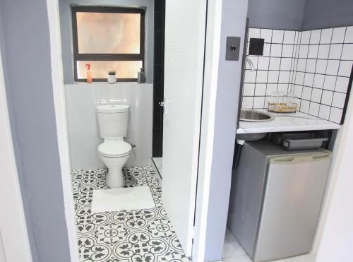 a small bathroom with a toilet and a sink at 4447 Guesthouse in Pimville