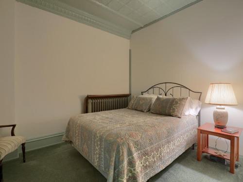 a bedroom with a bed and a table with a lamp at Shamokin Bed and Breakfast in Shamokin