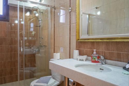 y baño con lavabo y ducha. en Nafsika Apartments en Párga