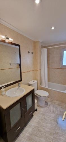 a bathroom with a sink and a toilet and a mirror at Gijón Centro-Playa para 3-5pax in Gijón