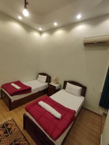 a bedroom with two beds with red blankets at Miami Hotel in Cairo