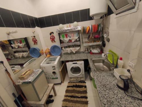 a small kitchen with a sink and a washing machine at Miami Hotel in Cairo