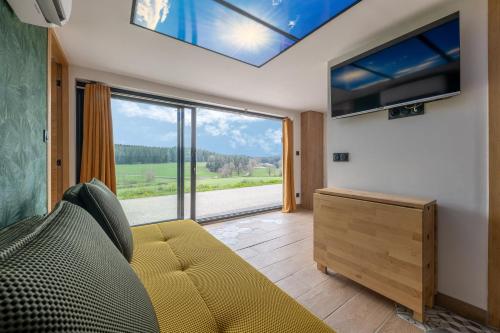 a living room with a couch and a large window at Prunières - Joli T2 dans la Haute-Loire in Saint-Pal-de-Mons