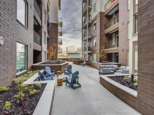 a patio with two blue chairs and a building at Urban Oasis in the Center of SLC in Salt Lake City