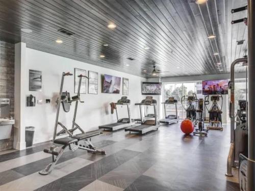a gym with several tread machines and a ball in it at Urban Oasis in the Center of SLC in Salt Lake City