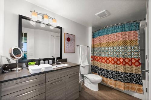 a bathroom with a toilet and a shower curtain at Urban Oasis in the Center of SLC in Salt Lake City