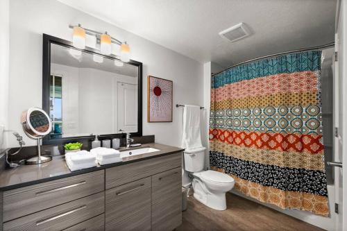 a bathroom with a toilet and a shower curtain at Urban Oasis in the Center of SLC in Salt Lake City