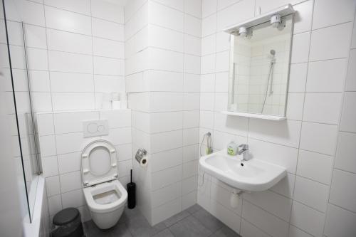 a white bathroom with a toilet and a sink at Old Strand Spirit in Prague