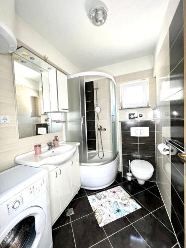 a bathroom with a sink and a toilet and a shower at Apartman Solin 3, parking in Solin