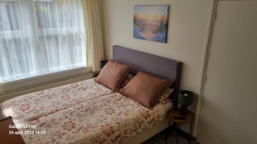 ein kleines Schlafzimmer mit einem Bett mit einer Blumendecke in der Unterkunft Vakantiewoning "Aan het Bosje" ZOUTELANDE - Strand 200m ! in Zoutelande
