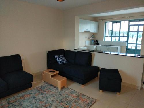 sala de estar con 2 sofás y cocina en Executive 1&2 Broom Airbnb in Gilgil Nakuru, en Gilgil