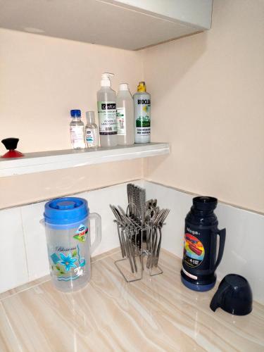 a kitchen counter with bottles and utensils on a shelf at Executive 1&2 Broom Airbnb in Gilgil Nakuru in Gilgil