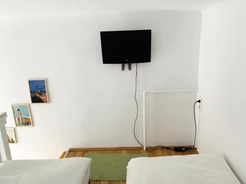 a living room with a tv on a white wall at Central Cozy Apartment in Cluj-Napoca