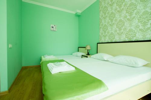 a bedroom with two beds with green walls at Chill Out Hotel in Tskaltubo
