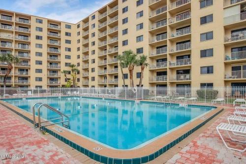 a swimming pool in front of a apartment building at Canaveral Towers Resort-Beach, Surf, Rocket Launches in Cape Canaveral
