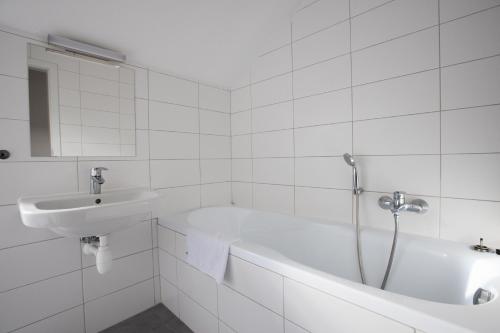 a white bathroom with a tub and a sink at Old Strand Spirit in Prague