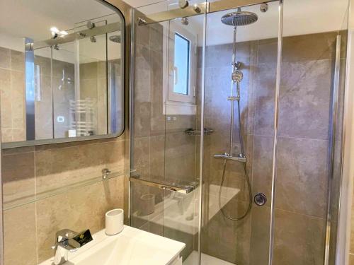 une salle de bain avec une douche en verre et un lavabo dans l'établissement Two en-suite bedroom apartment on La Croisette - Sea view, à Cannes