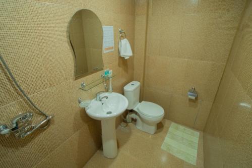 bagno con lavandino, servizi igienici e specchio di Chill Out Hotel a Tskhaltubo