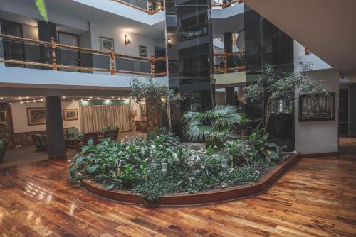a lobby with a large garden in the middle of a room at Patagonia Plaza Hotel in San Martín de los Andes