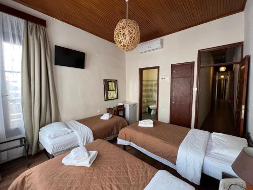 ein Hotelzimmer mit 2 Betten und einem Kronleuchter in der Unterkunft Rethymno House in Rethymno