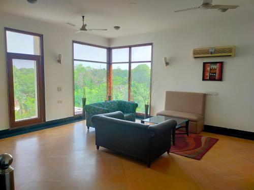 een woonkamer met een bank en een tafel bij Hotel Amisa Golf Course Road MG Road in Gurgaon