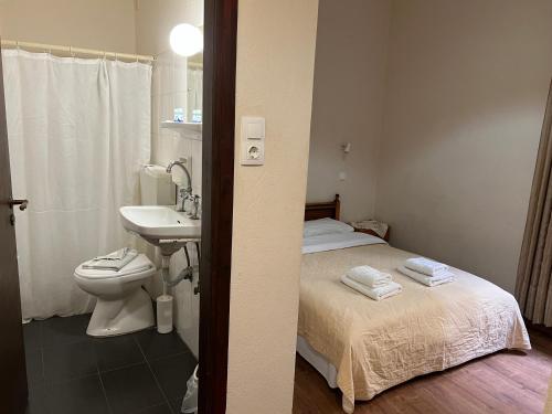 a bathroom with a bed and a sink and a toilet at Rethymno House in Rethymno Town