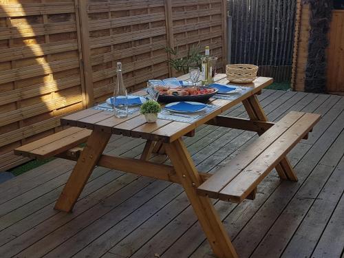 una mesa de picnic con un plato de comida en la cubierta en 3 pièces avec terrasse arborée, en Arcachon