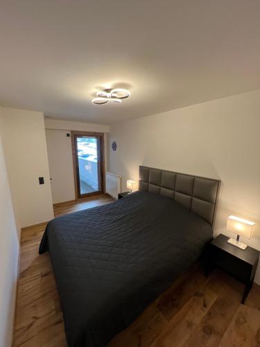 une chambre avec un grand lit et deux lampes dans l'établissement Résidence de l'Ariondaz - Courchevel, à Courchevel