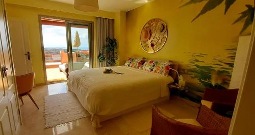 a bedroom with a large bed and a large window at Wellness-Penthaus am Meer in Palm-mar