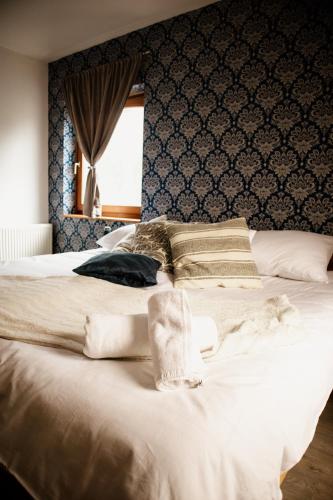 a bedroom with a large white bed with blue wallpaper at Sipos Borház és Vendégház in Badacsonyörs