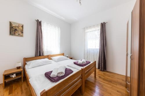 斯普利特Apartment Sergio的卧室里有一张床，床上放着两条毛巾。